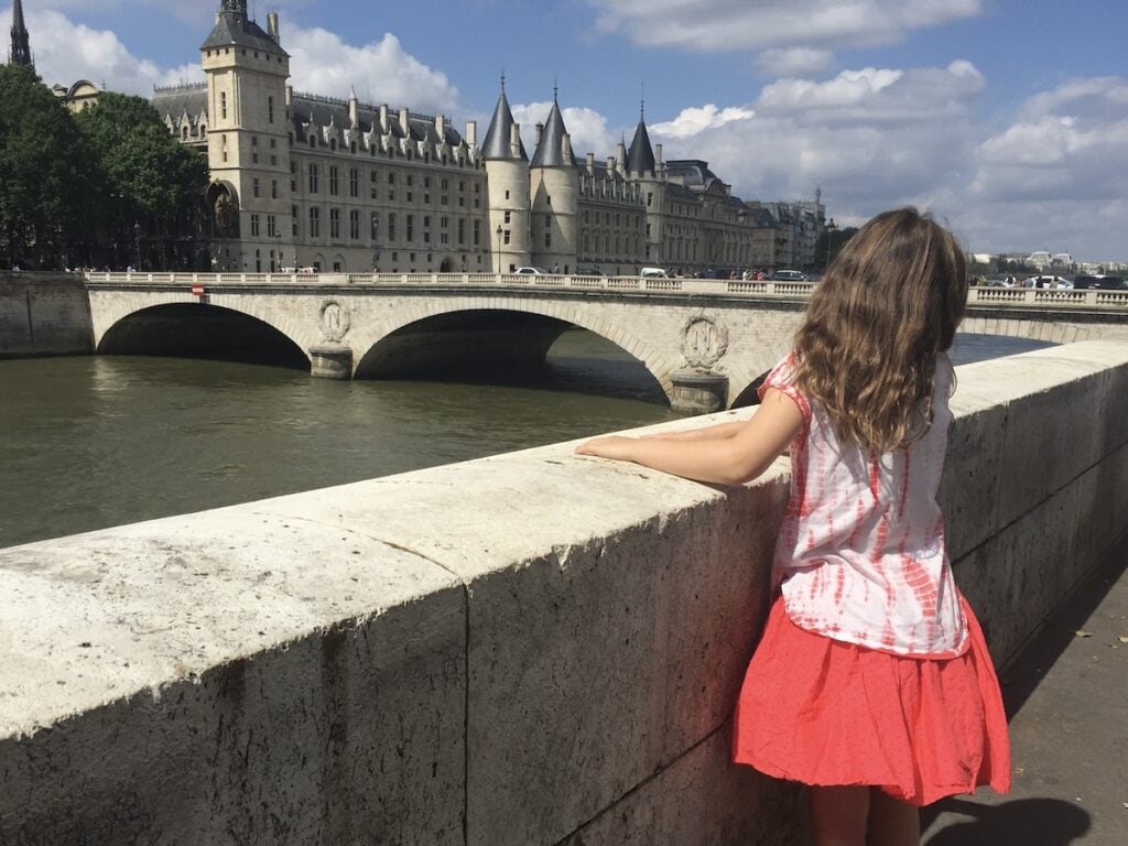 A child walking along the Seine in Paris