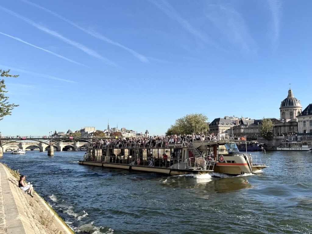 A boat tour going along the Seine River in Paris.