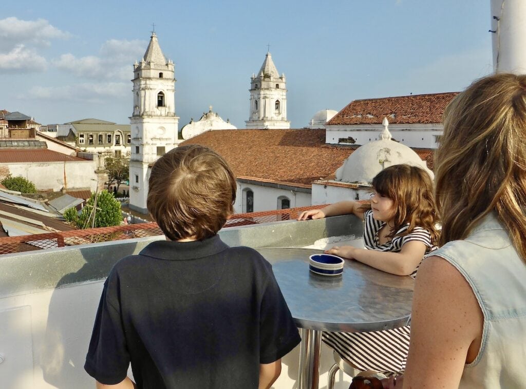 Mom and kids looking over rooftop from a rooftop patio in Casco Viejo Panama at Golden Hour