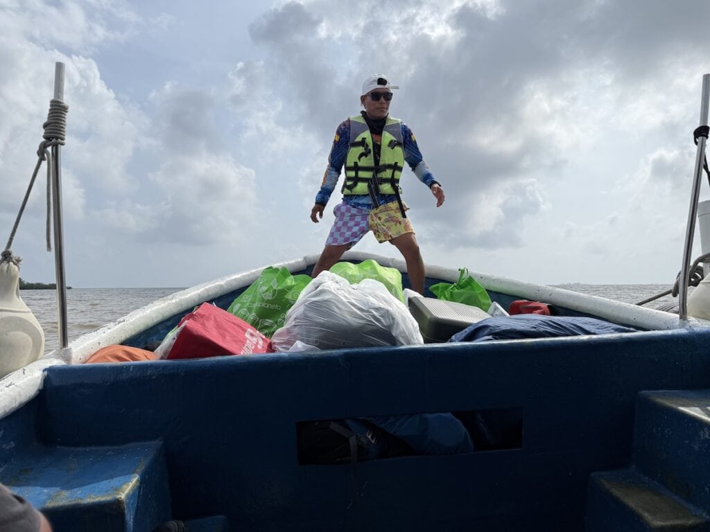A person loading a boat in Guna Yala for transport to a catamaran.