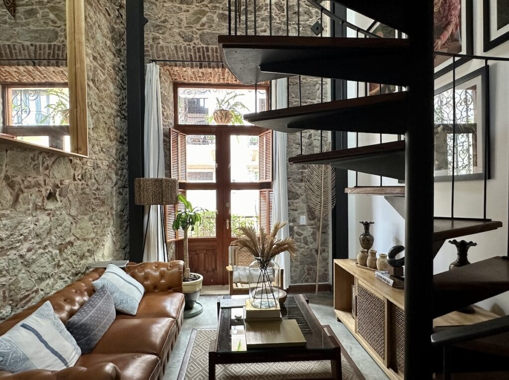 Elegant duplex guest room at Amarla Boutique Hotel in Casco Viejo, Panama, featuring a king bed, high ceilings, historic architecture, and contemporary design.