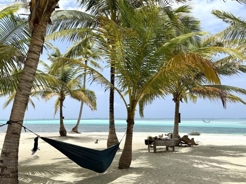 A nearly deserted island in Guna Yala, Panama, with palm trees, hammocks, white sand, and turquoise Caribbean water.