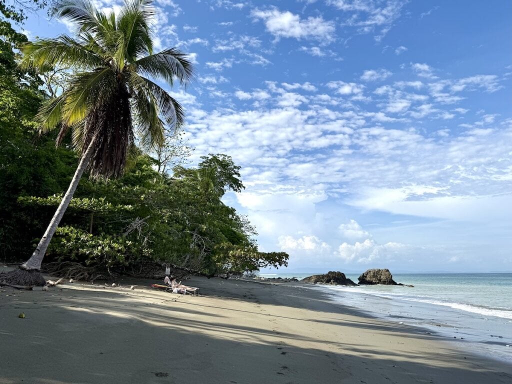 Person relaxing on a beach below Lapa Rios Lodge, Costa Rica